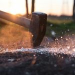 התמונה מראה פטיש מכה על משטח וניצוצות ניתזים